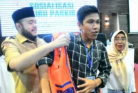 Wali Kota Padang Fadly Amran memasangkan rompi kepada salah satu peserta sosialisasi di Hotel Ocean Beach, Selasa (18/11/2025). (Foto: Prokopim Padang)