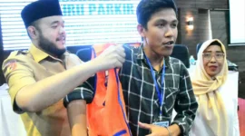 Wali Kota Padang Fadly Amran memasangkan rompi kepada salah satu peserta sosialisasi di Hotel Ocean Beach, Selasa (18/11/2025). (Foto: Prokopim Padang)