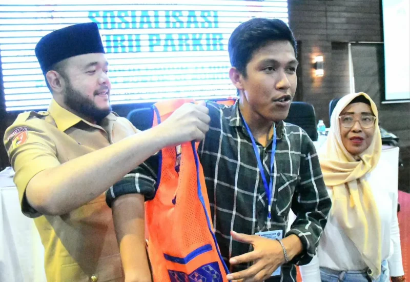 Wali Kota Padang Fadly Amran memasangkan rompi kepada salah satu peserta sosialisasi di Hotel Ocean Beach, Selasa (18/11/2025). (Foto: Prokopim Padang)