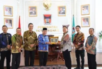 Wakil Wali Kota Padang, Maigus Nasir menyerahkan cenderamata kepada perwakilan rombongan dari Pemkab Lampung Timur. (Foto: Prokopim Padang)