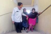 Wakil Wali Kota Padang Maigus Nasir menuntun warga naik ke shelter SMPN 25 Padang. (Foto: Diskominfo Padang)