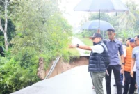 Bupati Padang Pariaman, John Kenedy Azis meninjau lokasi jalan terban di ruas Padang Baru–Kalawi, Nagari Parikmalintang, Minggu (23/11/2025). (Foto: Kominfo Padang Pariaman)
