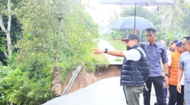 Bupati Padang Pariaman, John Kenedy Azis meninjau lokasi jalan terban di ruas Padang Baru–Kalawi, Nagari Parikmalintang, Minggu (23/11/2025). (Foto: Kominfo Padang Pariaman)