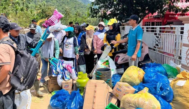 Ketua DWP Kabupaten Pessel, Ny Een Reva Yuliasman, (baju kuning) bersama rombongan saat mengantarkan bantuan ke nagari yang terdampak bencana di Kecamatan Bayang Utara. (Foto: Dok. Imam)