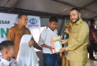 Wali Kota Padang Fadly Amran menyerahkan secara simbolis bantuan perlengkapan sekolah gratis kepada siswa yang terdampak banjir bandang, Senin (15/12/2025). (Foto: Prokopim Padang)