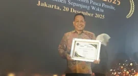 Anggota Bawaslu Pessel, Bambang Putra Niko memperlihatkan piagam penghargaan terbaik I tingkat nasional. (Foto: Dok. Humas Bawaslu)