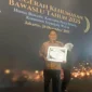 Anggota Bawaslu Pessel, Bambang Putra Niko memperlihatkan piagam penghargaan terbaik I tingkat nasional. (Foto: Dok. Humas Bawaslu)