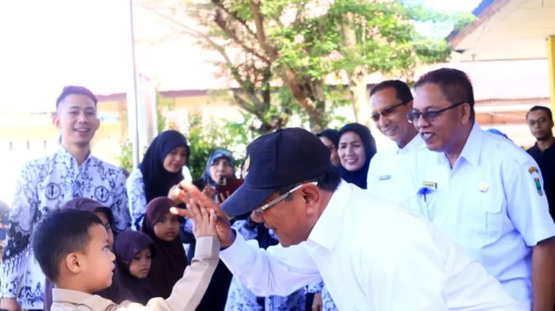 Bupati Padang Pariaman Jhon Kenedy Azis menyerahkan bantuan seragam sekolah gratis kepada siswa, Rabu (24/12/2025). (Foto: Kominfo Padang Pariaman)