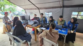 Disdukcapil Padang memberikan pelayanan administrasi kependudukan bagi warga terdampak banjir bandang di Huntara Lubuk Buaya, Jumat (19/12/2025). (Foto: Diskominfo Padang)