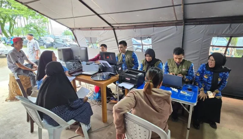 Disdukcapil Padang memberikan pelayanan administrasi kependudukan bagi warga terdampak banjir bandang di Huntara Lubuk Buaya, Jumat (19/12/2025). (Foto: Diskominfo Padang)