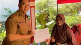 Kepala Disdukcapil Padang Teddy Antonius menyerahkan dokumen kependudukan kepada warga terdampak banjir. (Foto: FB Diskominfo Padang)