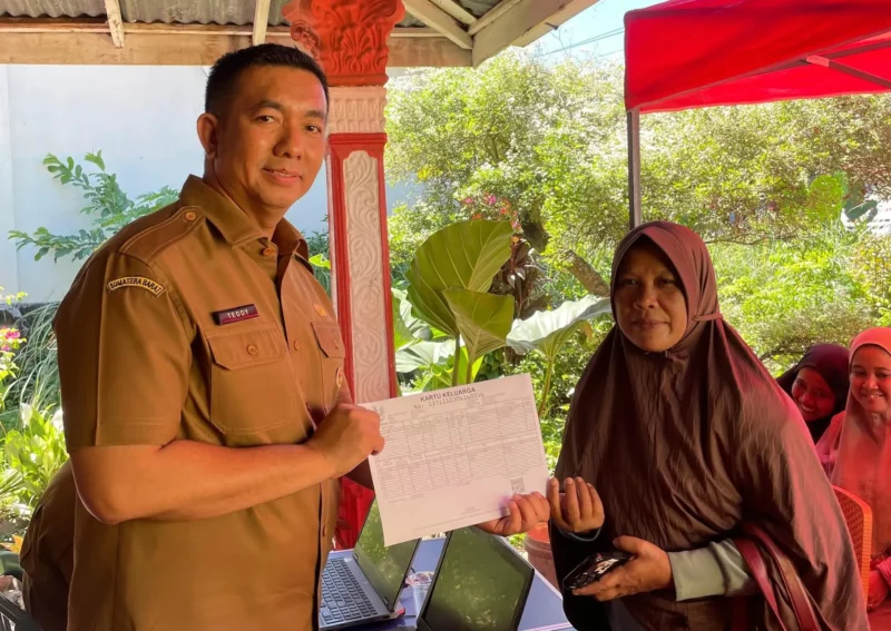 Kepala Disdukcapil Padang Teddy Antonius menyerahkan dokumen kependudukan kepada warga terdampak banjir. (Foto: FB Diskominfo Padang)