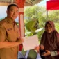 Kepala Disdukcapil Padang Teddy Antonius menyerahkan dokumen kependudukan kepada warga terdampak banjir. (Foto: FB Diskominfo Padang)