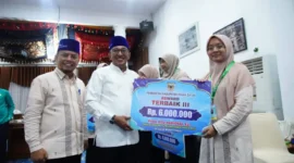 Bupati Tanah Datar Eka Putra menyerahkan bonus kepada kafilah MTQ, Kamis (18/12/2025) malam. (Foto: Prokopim Tanah Datar)