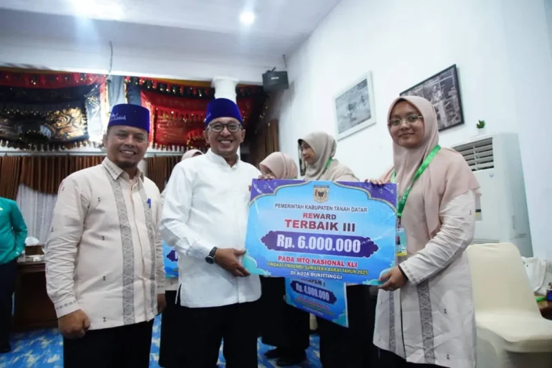 Bupati Tanah Datar Eka Putra menyerahkan bonus kepada kafilah MTQ, Kamis (18/12/2025) malam. (Foto: Prokopim Tanah Datar)