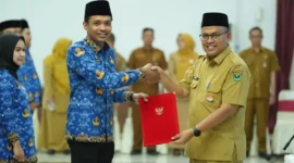 Sekdaprov Sumbar, Arry Yuswandi secara simbolis menyerahkan SK PPPK Paruh Waktu Pemprov Sumbar di Auditorium Gubernuran, Senin (29/12/2025). (Foto: ADPSB)