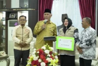 Gubernur Sumbar Mahyeldi Ansharullah menerima bantuan PGRI Bengkalis sebesar Rp420 juta untuk guru dan sekolah terdampak bencana di Sumbar. (Foto: ADPSB)