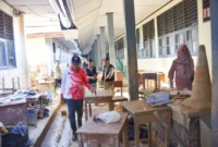 Pemko Padang mengerahkan ASN untuk membersihkan material sisa lumpur di SMAN 12 Padang, Minggu (7/12/2025). (Foto: Prokopim Padang)