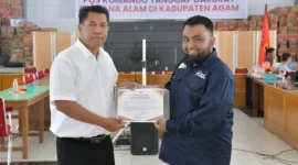 Spesialis Kebencanaan Human Initiative Pusat, Jumarsono menyerahkan bantuan kepada Sekdakab Agam, Dr Muhammad Lutfi AR. (Foto: AMC)