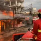 Petugas Damkar Padang memadamkan api yang menghanguskan sembilan petak toko dan satu rumah warga di Jalan Prof Hamka, Kecamatan Padang Utara, Minggu (21/12/2025) pagi.  (Foto: Dinas Damkar Padang)