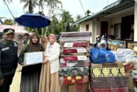 Ketua TP-PKK Kota Padang, Ny. Dian Puspita Fadly Amran menyalurkan bantuan untuk warga terdampak bencana di Kecamatan Koto Tangah, Minggu (30/11/2025). (Foto: Diskominfo Padang)