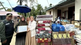 Ketua TP-PKK Kota Padang, Ny. Dian Puspita Fadly Amran menyalurkan bantuan untuk warga terdampak bencana di Kecamatan Koto Tangah, Minggu (30/11/2025). (Foto: Diskominfo Padang)