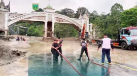 Tim gabungan berjibaku membersihkan sisa lumpur di kawasan Jembatan Kembar, Silaing Bawah, Kota Padang Panjang. (Foto: Kominfo Padang Panjang)  