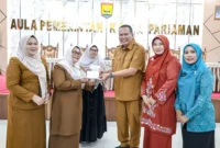Wali Kota Pariaman Yota Balad saat penyerahan secara simbolis penggantian biaya transportasi kepada kader dasawisma di Aula Balai Kota Pariaman, Senin (15/12/2025). (Foto: Kominfo Pariaman)
