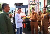 Bupati Pessel, Hendrajoni didampingi Kepala Dinas Pertanian, Madrianto saat menyerahkan bantuan secara simbolis kepada salah satu ketua kelompok tani. (Foto: Dok. Be)