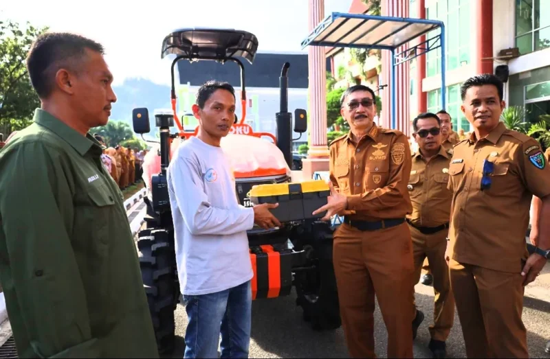 Bupati Pessel, Hendrajoni didampingi Kepala Dinas Pertanian, Madrianto saat menyerahkan bantuan secara simbolis kepada salah satu ketua kelompok tani. (Foto: Dok. Be)