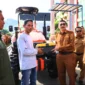 Bupati Pessel, Hendrajoni didampingi Kepala Dinas Pertanian, Madrianto saat menyerahkan bantuan secara simbolis kepada salah satu ketua kelompok tani. (Foto: Dok. Be)