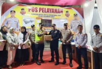 Sekdakab Pasbar Doddy San Ismail menyerahkan bingkisan kepada petugas di pos pengamanan Nataru pada Rabu (24/12/2025) malam. (Foto: Kominfo Pasbar)