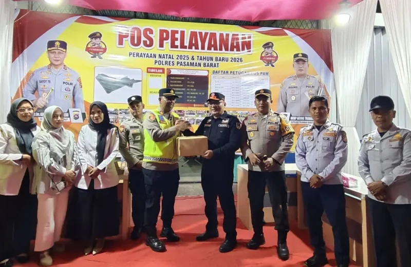 Sekdakab Pasbar Doddy San Ismail menyerahkan bingkisan kepada petugas di pos pengamanan Nataru pada Rabu (24/12/2025) malam. (Foto: Kominfo Pasbar)