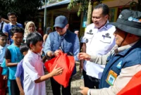 Staf Khusus Mendikdasmen Didik Suhardi didampingi Wali Kota Pariaman Yota Balad menyerahkan bingkisan kepada siswa di Kota Pariaman, Rabu (24/12/2025). (Foto: Kominfo Pariaman)