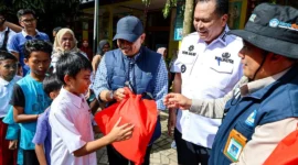 Staf Khusus Mendikdasmen Didik Suhardi didampingi Wali Kota Pariaman Yota Balad menyerahkan bingkisan kepada siswa di Kota Pariaman, Rabu (24/12/2025). (Foto: Kominfo Pariaman)