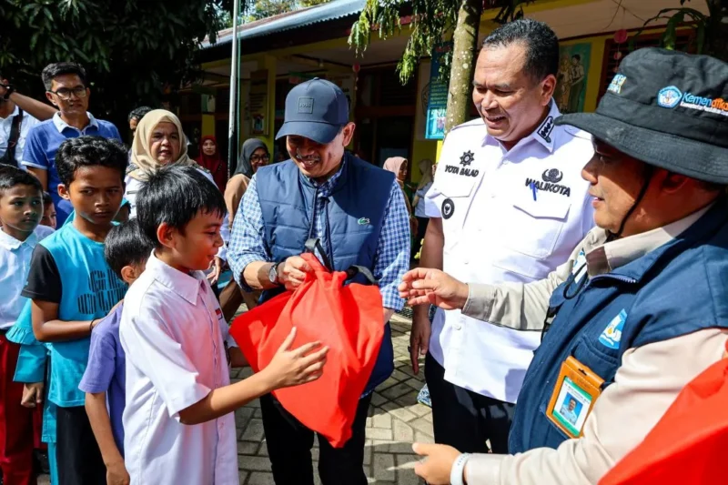 Staf Khusus Mendikdasmen Didik Suhardi didampingi Wali Kota Pariaman Yota Balad menyerahkan bingkisan kepada siswa di Kota Pariaman, Rabu (24/12/2025). (Foto: Kominfo Pariaman)