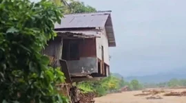 Satu unit rumah di kawasan bantaran Sungai Lubuk Minturun, Koto Tuo, Kelurahan Koto Panjang, Kecamatan Koto Tangah terlihat “tergaing-gaing” akibat tapaknya terkikis banjir bandang pada 28 November 2025 lalu. (Foto: Diskominfo Padang) 