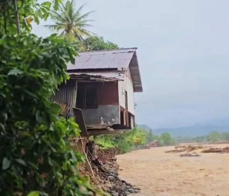 Satu unit rumah di kawasan bantaran Sungai Lubuk Minturun, Koto Tuo, Kelurahan Koto Panjang, Kecamatan Koto Tangah terlihat “tergaing-gaing” akibat tapaknya terkikis banjir bandang pada 28 November 2025 lalu. (Foto: Diskominfo Padang) 