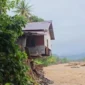 Satu unit rumah di kawasan bantaran Sungai Lubuk Minturun, Koto Tuo, Kelurahan Koto Panjang, Kecamatan Koto Tangah terlihat “tergaing-gaing” akibat tapaknya terkikis banjir bandang pada 28 November 2025 lalu. (Foto: Diskominfo Padang) 