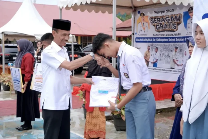 Wakil Bupati Solok Selatan H. Yulian Efi menyerahkan secara simbolis baju seragam gratis kepada siswa. (Foto: Humas Pemkab Solsel)