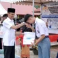 Wakil Bupati Solok Selatan H. Yulian Efi menyerahkan secara simbolis baju seragam gratis kepada siswa. (Foto: Humas Pemkab Solsel)