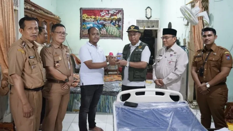 Wakil Wali Kota Padang, Maigus Nasir menyerahkan bantuan tempat tidur kepada Yarni (62) di Kelurahan Parupuak Tabiang, Kecamatan Koto Tangah, Senin (12/1/2026). (Foto: Prokopim Padang)