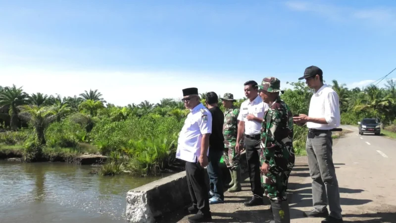 Bupati Pasbar Yulianto meninjau perbaikan jalan poros Ranah Pasisie–Suak Maligi yang rusak akibat banjir, Rabu (31/12). (Foto: Kominfo Pasbar)
