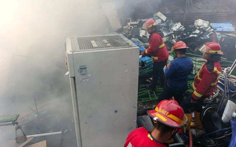 Petugas Damkar Padang memadamkan api di gudang penampung barang bekas di Jalan Bypass KM 13, Senin (27/1) pagi. (Foto: Dinas Damkar Padang)