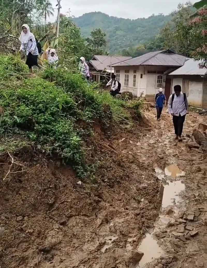 
Para siswa dan guru di Nagari Ngalau Gadang terpaksa harus berjalan kaki menerobos jalanan yang masih tertimbun longsor untuk menuju sekolah. (Foto: Dok. Novermal)