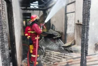 Petugas memadamkan kebakaran yang melanda rumah warga dan rumah makan Ampera di Jalan Jati Adabiah, Senin (26/1/2026). (Foto: Dinas Damkar Padang)