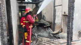 Petugas memadamkan kebakaran yang melanda rumah warga dan rumah makan Ampera di Jalan Jati Adabiah, Senin (26/1/2026). (Foto: Dinas Damkar Padang)