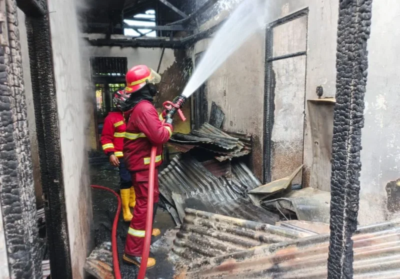 Petugas memadamkan kebakaran yang melanda rumah warga dan rumah makan Ampera di Jalan Jati Adabiah, Senin (26/1/2026). (Foto: Dinas Damkar Padang)