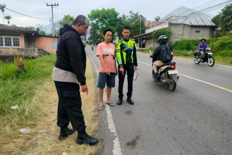 Polisi menunjukkan TKP kecelakaan lalu lintas di ruas Jalan Lintas Solok–Padang, tepatnya di Jorong Gaduang Dama, Nagari Cupak, Kecamatan Gunung Talang, Kabupaten Solok, Rabu (28/1/2026). (Foto: Satlantas Polres Solok)