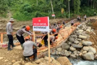 Personil Sat Brimob Polda Sumbar membangun jembatan darurat di Kampung Tangah, Kecamatan Palembayan, Kabupaten Agam. (Foto: Ist)